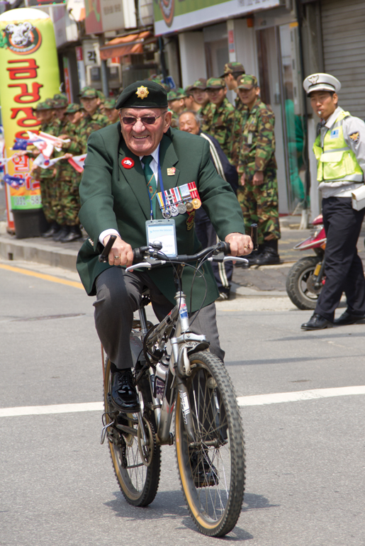 Veteran Guy Vachon of Ottawa rides a bike during the parade at Kapyong. [PHOTO: DAN BLACK]