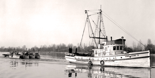A Fishermen’s Naval Reserve vessel hauls in confiscated boats. [PHOTO: LIBRARY AND ARCHIVES CANADA—PA134099]