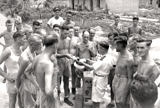 Liberated PoWs gather around for some smokes.  [PHOTO: PO JACK HAWES, LIBRARY AND ARCHIVES CANADA—PA151738]