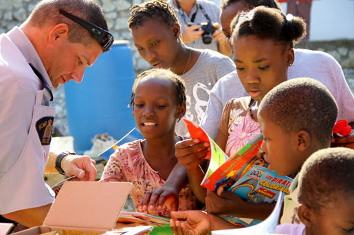 RCMP Staff Sergeant Richard Martel hands out colouring books to children at the orphanage. [PHOTO: DAN BLACK]