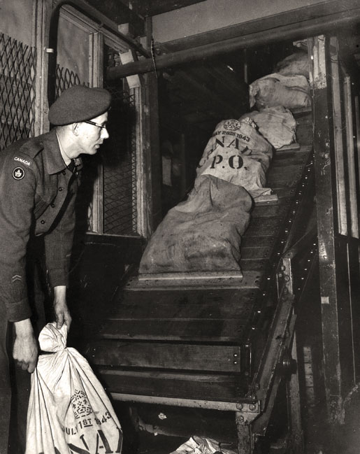 Private E.S. Tooke loads bags of mail in London, England, 1945. [PHOTO: ARTHUR L. COLE, LIBRARY AND ARCHIVES CANADA—PA114497]