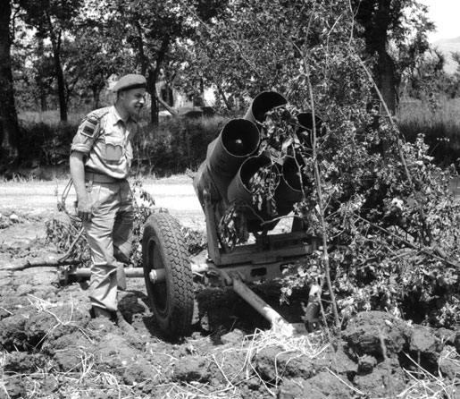 Lieutenant W.H. Salter examines a loaded Nebelwerfer, 1944. [PHOTO: STRATHY E. SMITH, LIBRARY AND ARCHIVES CANADA—PA169113]