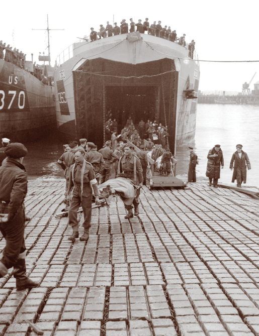 Canadian soldiers wounded on the Normandy beachhead are carried off a Landing Ship Tank in Southampton, England, June 1944. [PHOTO: LT. MICHAEL M. DEAN, LIBRARY AND ARCHIVES CANADA—PA131437]