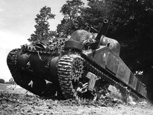 A Canadian Sherman tank rolls over a rise on the Normandy battlefield, 1944. [PHOTO: LEGION MAGAZINE ARCHIVES]