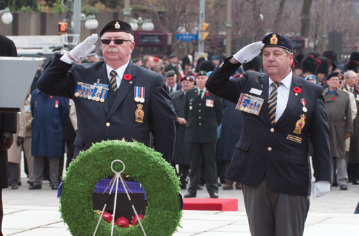 Dominion President Gordon Moore (left) salutes after placing a wreath. Next to him is wreath bearer Ken Sorrenti, Commander of District G, Ontario Command. [PHOTO: MARC FOWLER & RANDY HARQUAIL/METROPOLIS STUDIO]