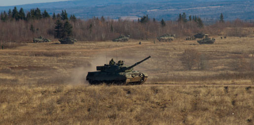 Tanks and LAV IIIs charge out of gullies during exercises at Canadian Forces Base Gagetown. [PHOTO: TOM MacGREGOR]