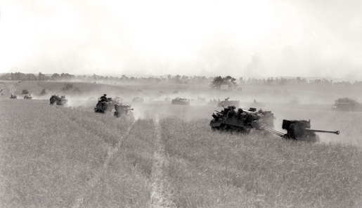 Vehicles from the 3rd Canadian Division kick up dust as they advance near Bretteville-le-Rabet. [PHOTO: DONALD I. GRANT, LIBRARY AND ARCHIVES CANADA—PA116536]