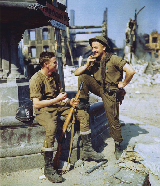 Two privates relax in a square in Falaise. [PHOTO: LIBRARY AND ARCHIVES CANADA—E010786190] 