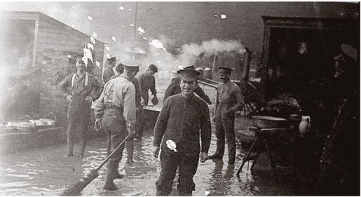 Corporal Thomas Gillian (centre) and other soldiers standing in muddy water.