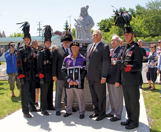 Mohawk Branch President Louis Stacey (centre) stands with members of the Voltiguers in front of the monument. [PHOTO: TOM MACGREGOR]