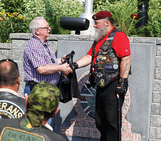 Dominion President Gordon Moore (left) presents a Legion Riders vest to CAV founder Paul Cane. [PHOTO: ADAM DAY]