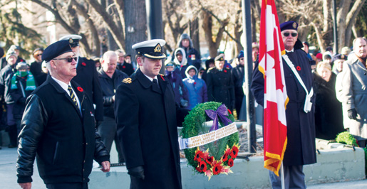 Regina Branch First Vice Ian Brown places a wreath on behalf of veterans groups, including the Legion. [PHOTO: TOM MacGREGOR]