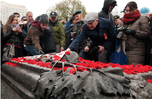 Canadians place poppies and flags on the Tomb of the Unknown Soldier. [PHOTO: METROPOLIS STUDIO]