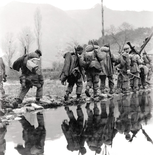 A company of the PPCLI moves in single file across rice paddies as it advances on enemy positions across the valley. [PHOTO: LIBRARY AND ARCHIVES CANADA—PA171228]