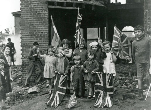 Young children in bomb scarred Battersea in south London with their Union flags. [PHOTO: LEGION MAGAZINE ARCHIVES]