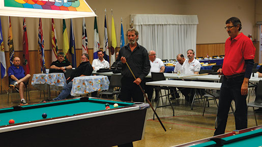 Jerry Carroll (left) chalks his cue as Danny Carroll looks on. [PHOTO: ADAM DAY]