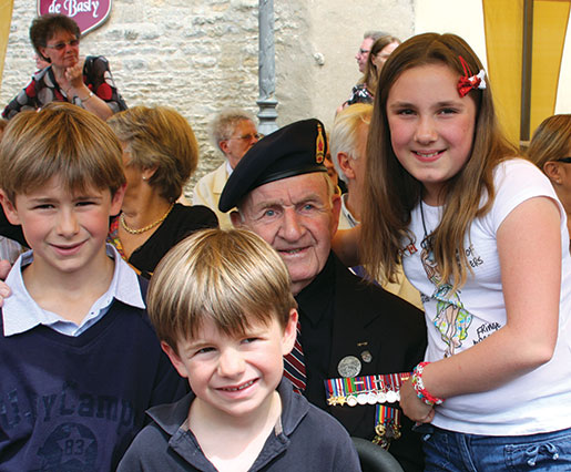 D-Day veteran Bud Hannam is surrounded by French children prior to a ceremony in Basly, France. [PHOTO: SHARON ADAMS]