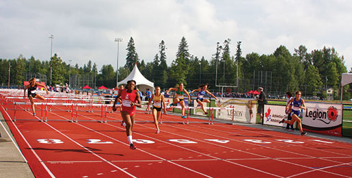 Miriam Abdul-Rashid (in red) takes the lead in women’s 300-metre hurdles. [PHOTO: sharon adams]