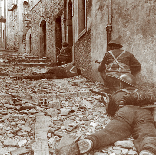 Members of the Carleton and York Regiment advance up a side street to rescue a comrade felled by a sniper’s bullet in Campochiaro, Italy,  on Oct. 23, 1943. [CANADIAN WAR MUSEUM/19920085-1030]