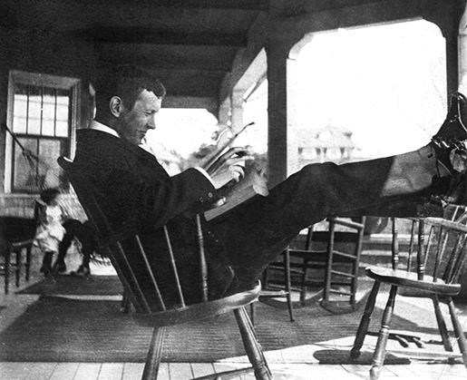 Book and cigar in hand, John McCrae relaxes at the holiday home of friends at Kennebunkport, Maine, where he spent a vacation in September 1903. [Guelph Civic Museum/M1968X.436.3]