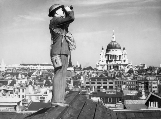 A Royal Observer Corps aircraft spotter scans the London skies for incoming bombers. St. Paul’s Cathedral is in the background. [Imperial War Museum]