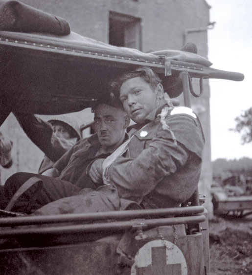 Wounded infantrymen near Carpiquet, France. [LAC/PA-169269]