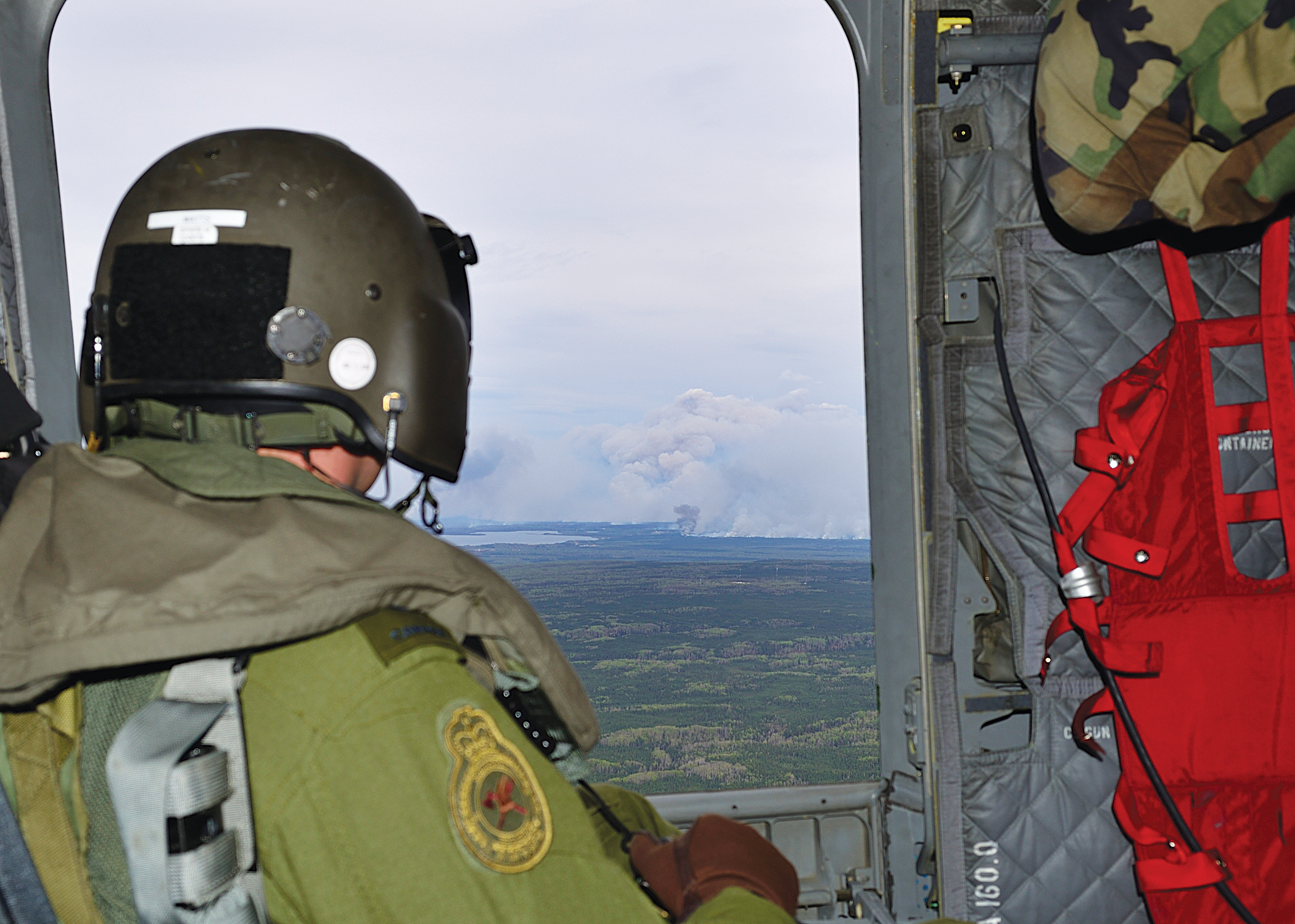 ENGLISH/ANGLAIS WA2016-0019-02 Corporal Greg Watts, Flight Engineer, observes wildfires near Fort McMurray from a CH-147F Chinook helicopter during the Canadian Armed Forces’ support to the Province of Alberta’s emergency response efforts. Photo by: MCpl Brandon O'Connell, 3 CDN DIV PA Copyright Notice © 2016 DND-MDN Canada