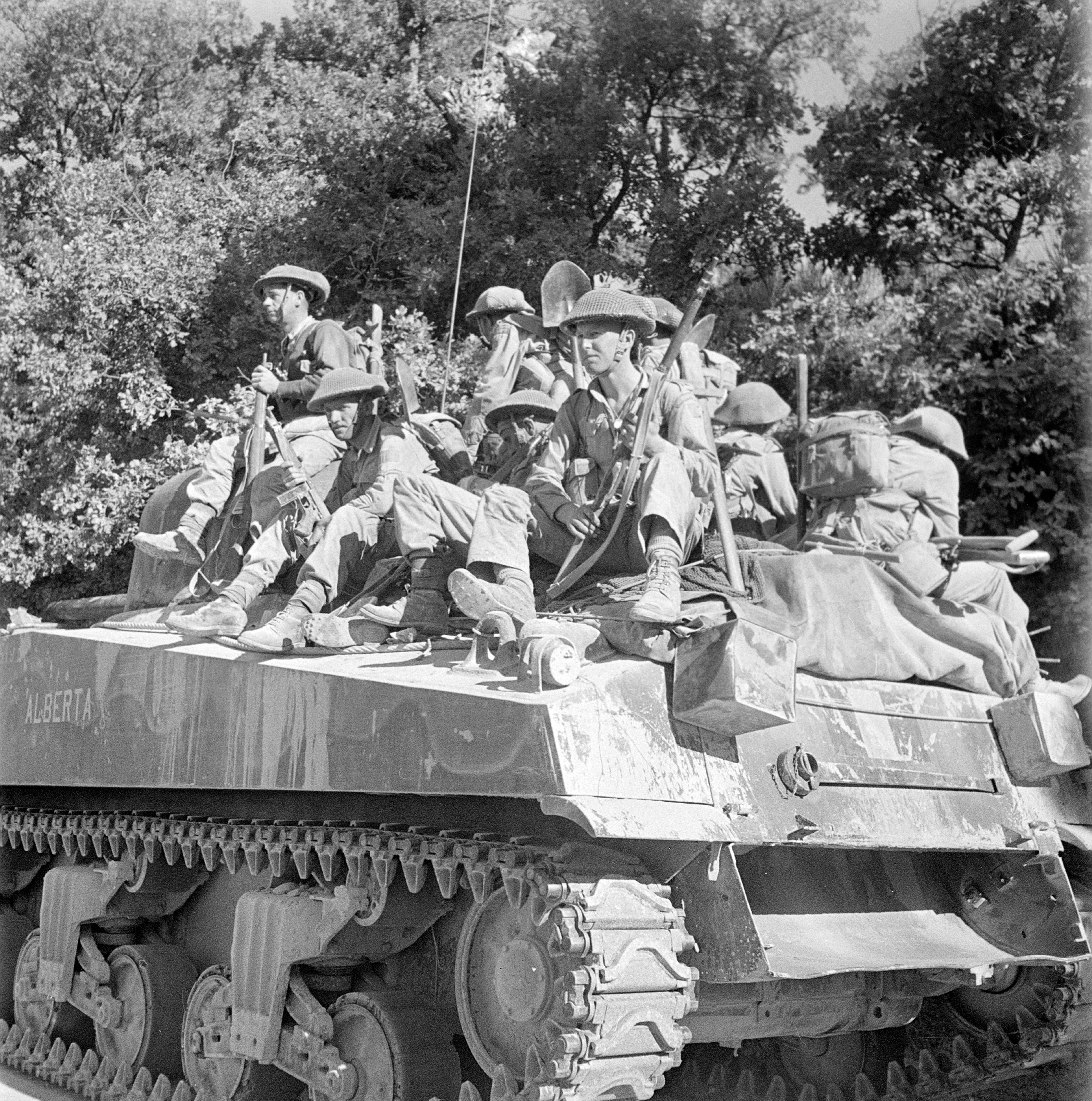 Infantrymen of the West Nova Scotia Regiment riding on a Sherman tank of the Calgary Regiment during the advance from Villapiano to Potenza, Italy, 18 September 1943.
