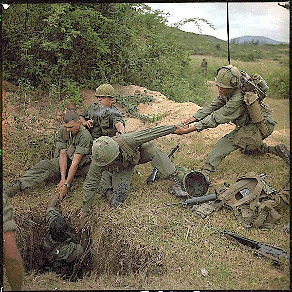 American reconnaissance troops lower a tunnel rat into his office during Operation Oregon, a 1966 U.S. Marine operation northwest of Hue, Thừa Thiên Province, South Vietnam. North Vietnamese fighters would often booby-trap the tunnels with venomous snakes.